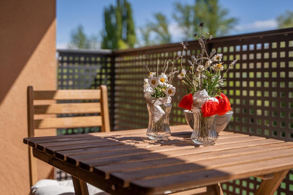 deux vases avec des fleurs assis sur une table en bois dans l'établissement Fuentes de la Hoz, à Aguatón