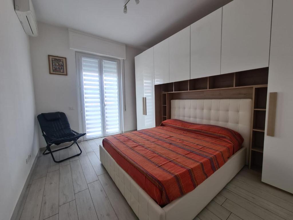 a bedroom with a large bed and a chair at CASA PANDA in Luni