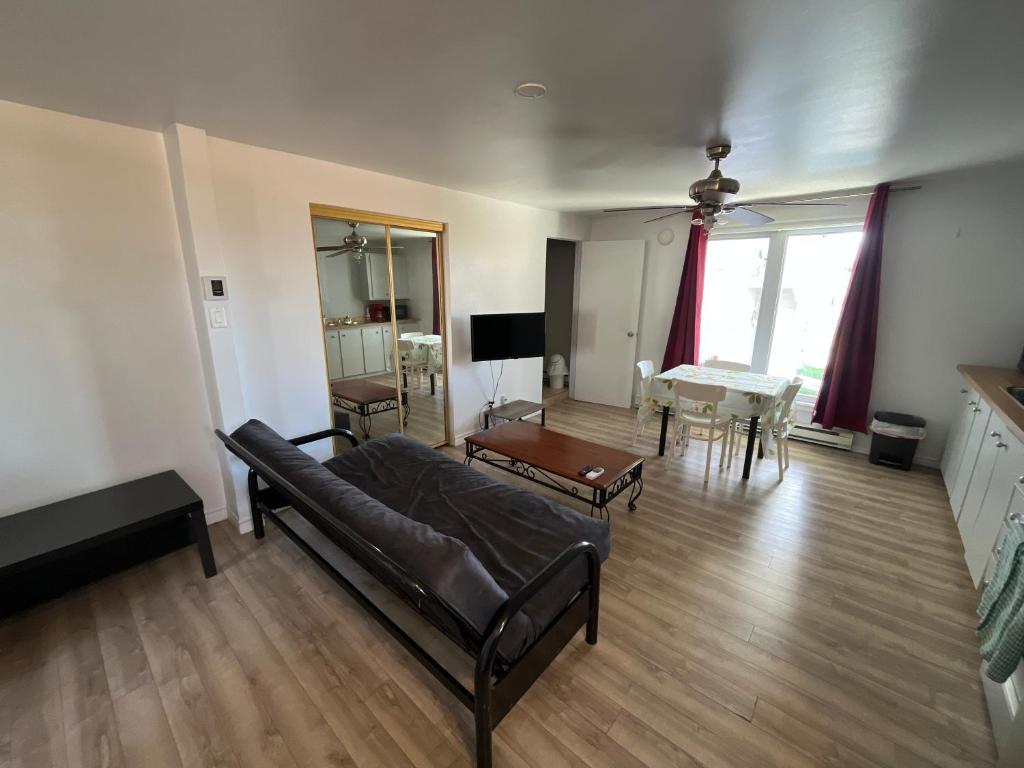 a living room with a couch and a table at Auberge Lac-Saint-Jean in Roberval