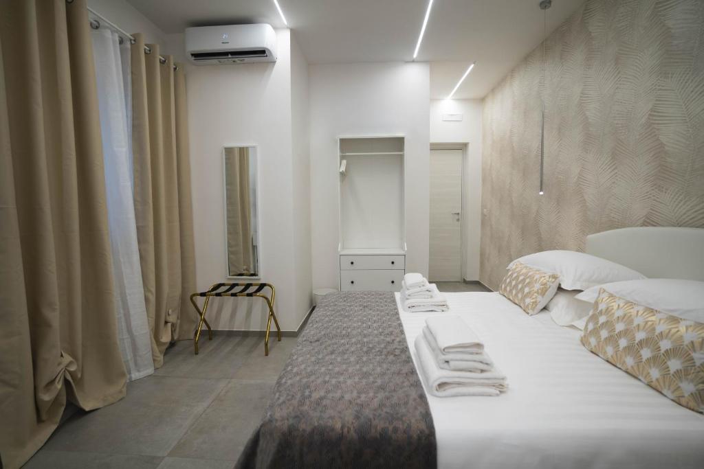 a room with a large bed with towels on it at Arco Alto Rooms in Bari