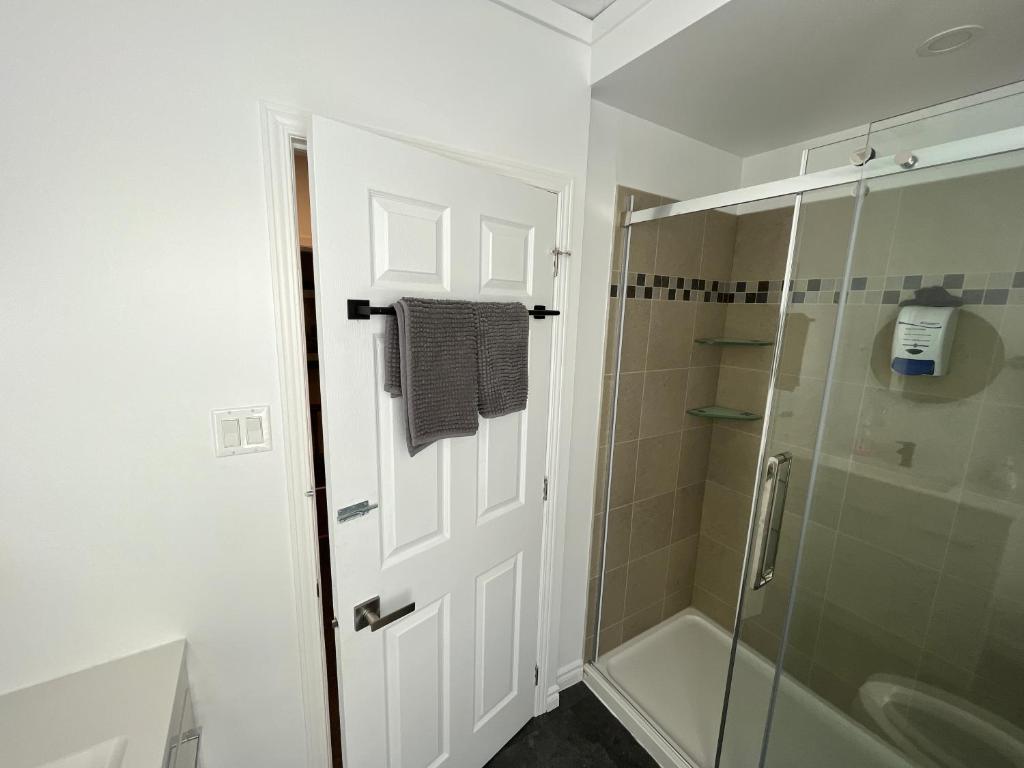 a bathroom with a shower and a glass door at Auberge Lac-Saint-Jean in Roberval