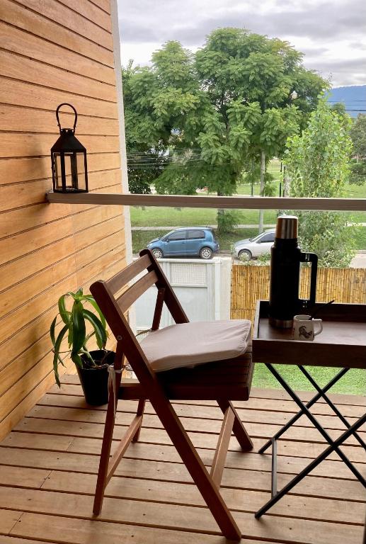a chair on a deck with a table and a lamp at Yerba Buena Lofts - Monoambiente con Cochera in Yerba Buena