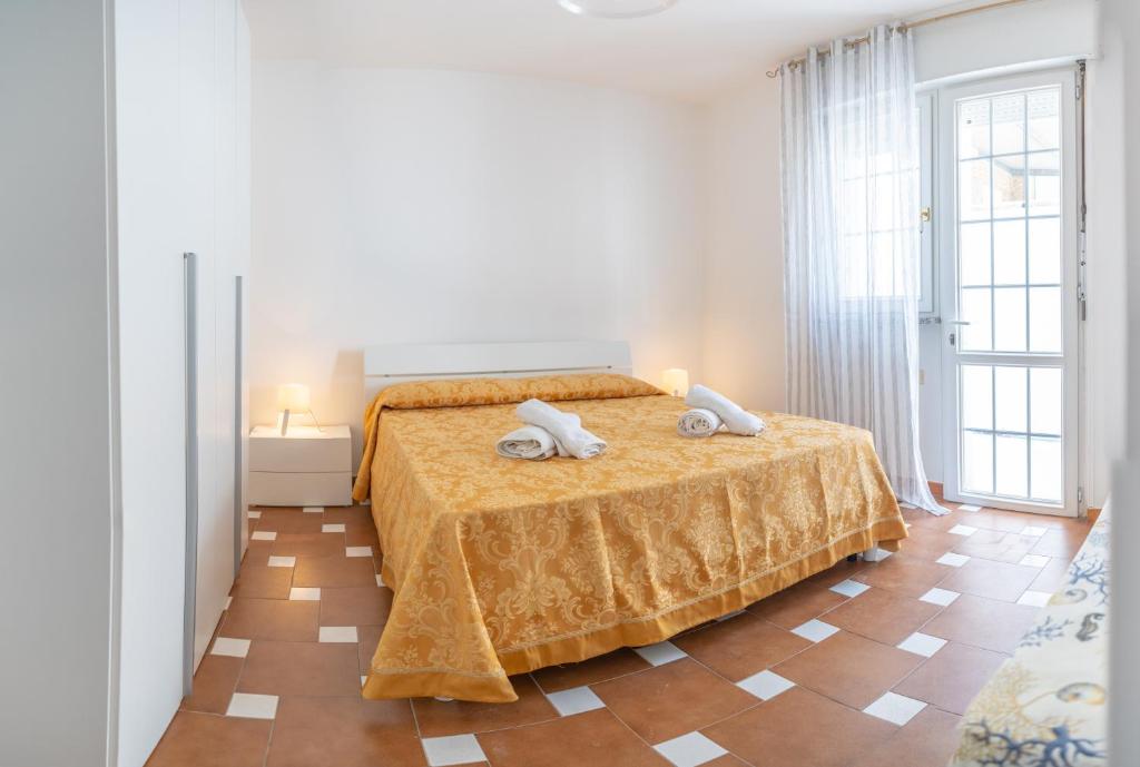 una camera da letto con un letto e due asciugamani di Casa al mare Le Campanelle a Marina di Pescoluse