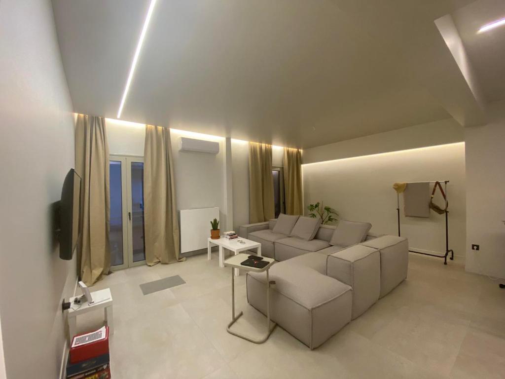 a living room with a couch and a tv at Sapfo Luxury Apartment in Athens in Athens