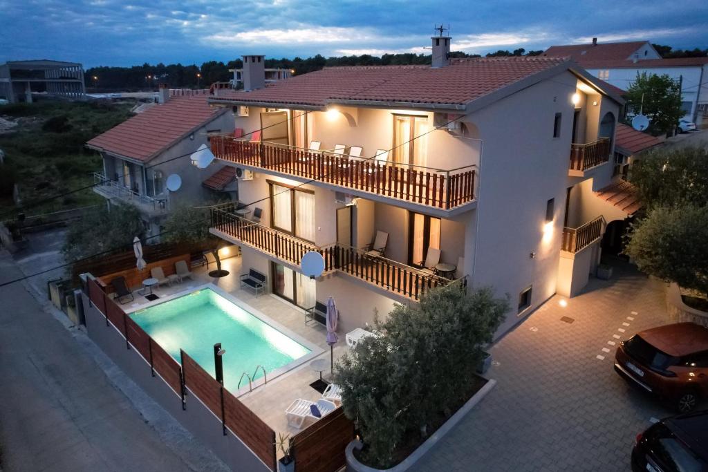 a villa with a swimming pool at night at Pool Apartments Julia in Zadar