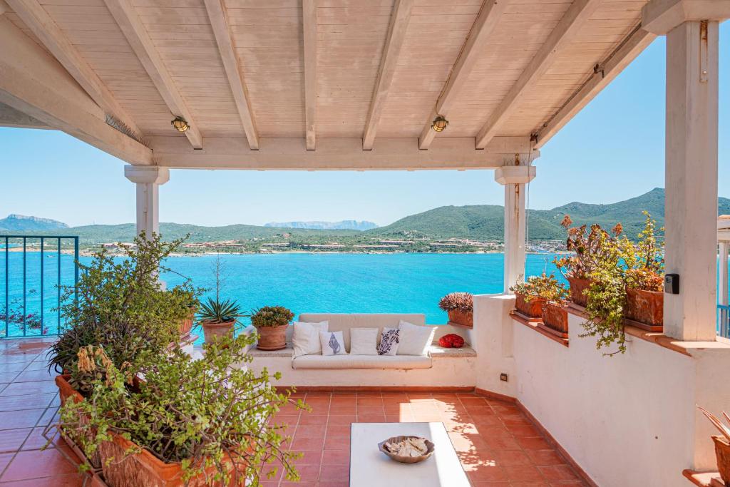 een patio met een bank en uitzicht op het water bij Casa Azzurra con Terrazza Vista Mare by Wonderful Italy in Golfo Aranci