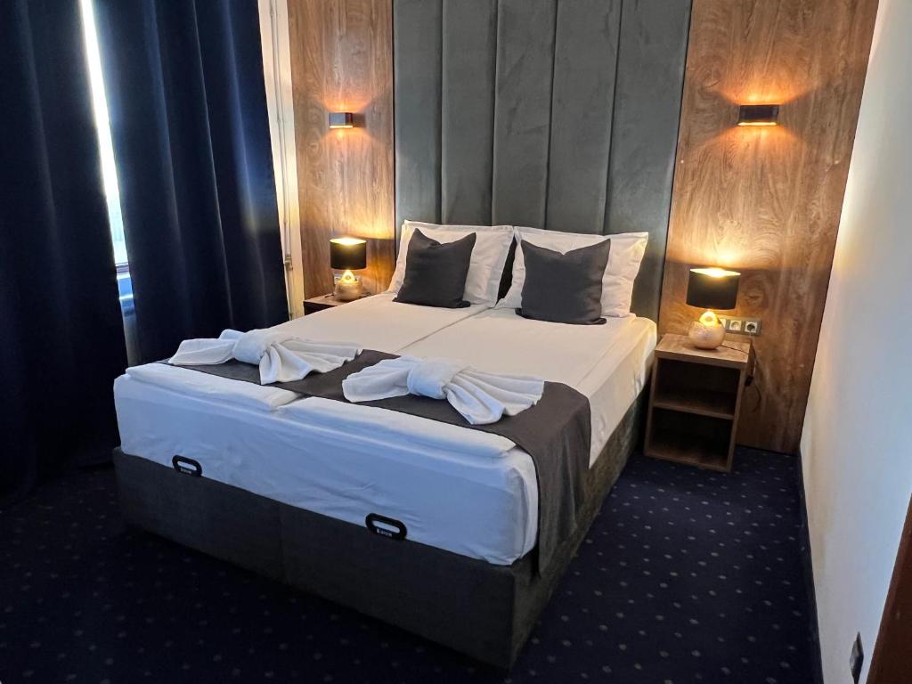 ein Schlafzimmer mit einem großen Bett mit weißer Bettwäsche und Kissen in der Unterkunft Saint George - Old Nesebar in Nessebar