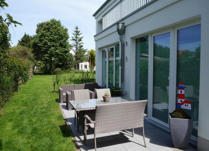 ヴァンガーオーゲにあるStrandperle; idyllisch gelegen mit Terrasse und Garten, für 4 Personenの家の隣のパティオ(テーブル、椅子付)