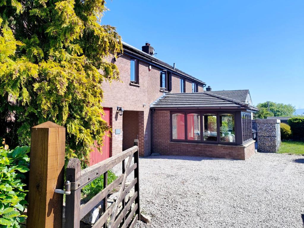 a house with a fence in front of a building at Yewtree House in Penrith
