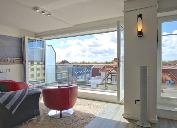 ヴァンガーオーゲにあるWoogeDiva - die höchste Wohnung Wangeroogesのリビングルーム(赤い椅子、大きな窓付)