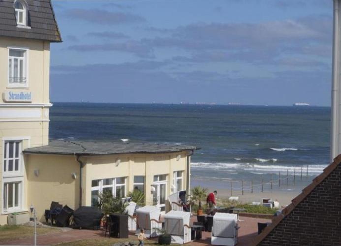 ヴァンガーオーゲにあるStormtüüt - Wunderschönes Feriendomizil für die junge Familie in Strandnäheの海岸と海の景色を望む建物
