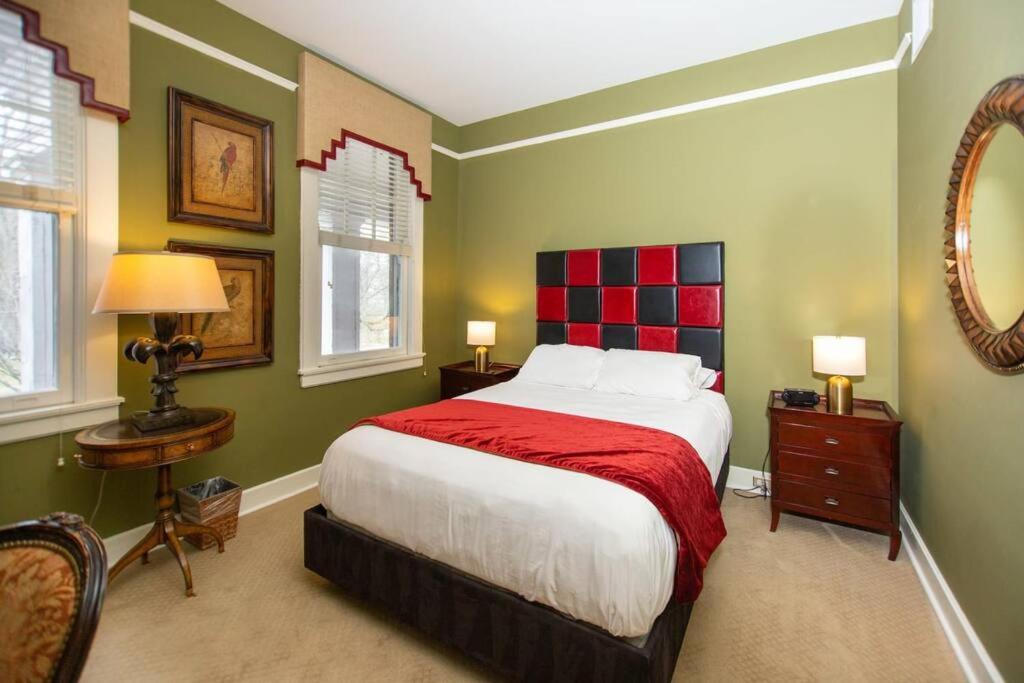 達拉姆的住宿－Cute Studio in Durham, 5 min to Downtown，一间卧室设有一张大床,拥有红色和绿色的墙壁