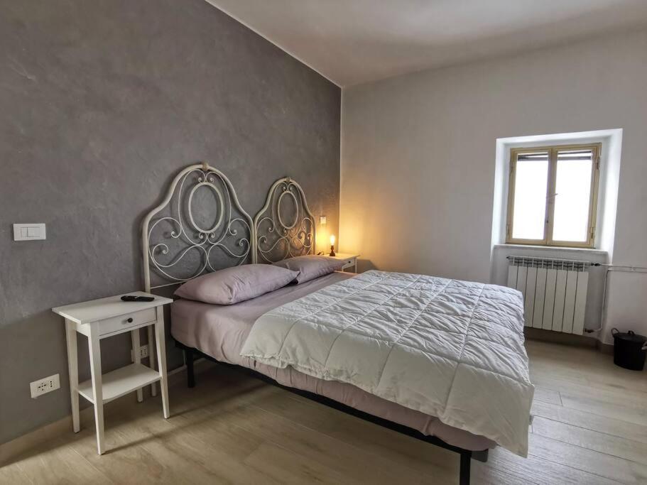 a bedroom with a bed and a table and a window at LamaDue - Casa Vacanze in Borra