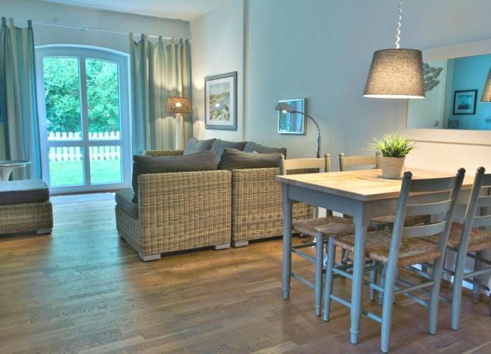 a living room with a table and a couch at WangerRose - Familienwohnung für Groß und Klein und Hundefreunde in Wangerooge