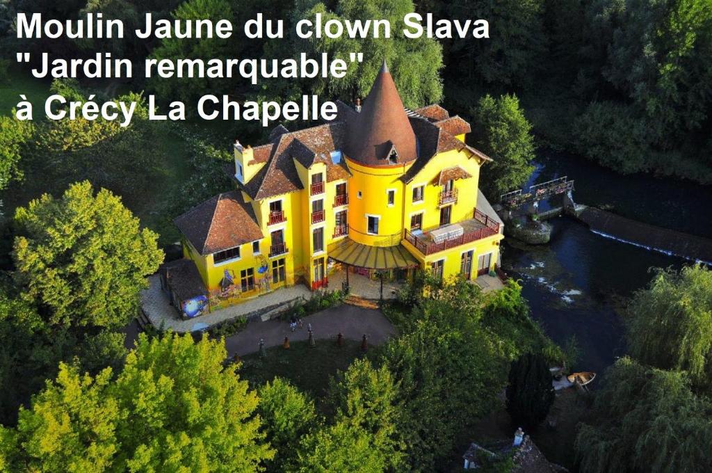 an aerial view of a large yellow house at Les Nympheas, appart, grand jardin au calme, parking gratuit,15 min Disneyland, in Crécy-la-Chapelle