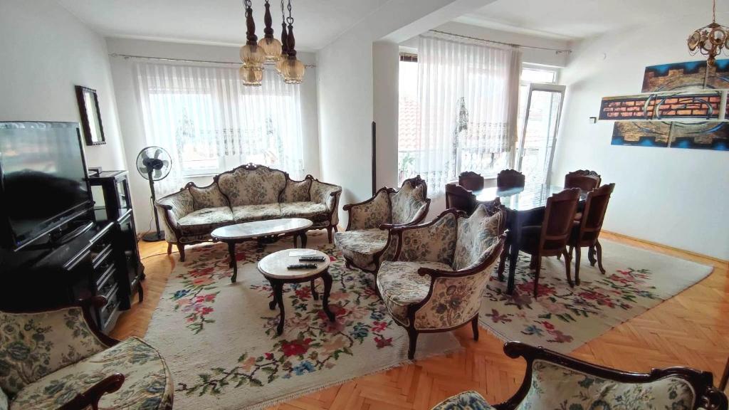 a living room with couches and a table and chairs at Apartment Smakjoski Center in Ohrid