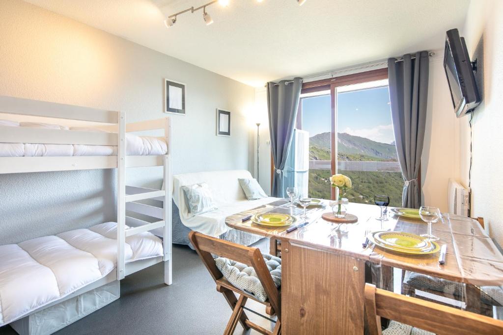 a room with a dining table and bunk beds at Le Freeride - 14ème étage avec vue sur montagne in Villarembert