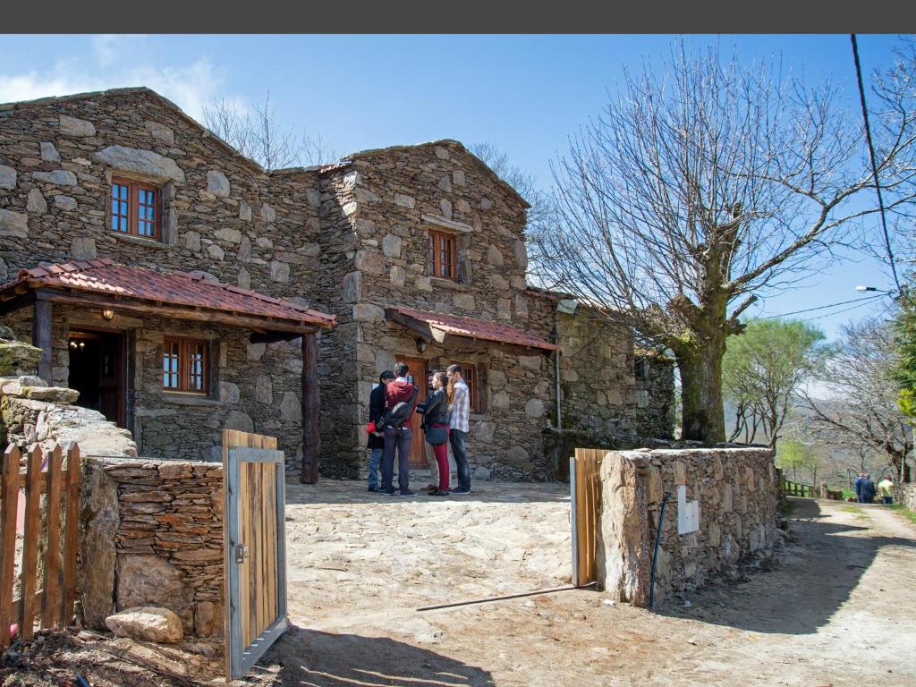 um grupo de pessoas do lado de fora de uma casa de pedra em Casas Dos Barreiros em Melgaço