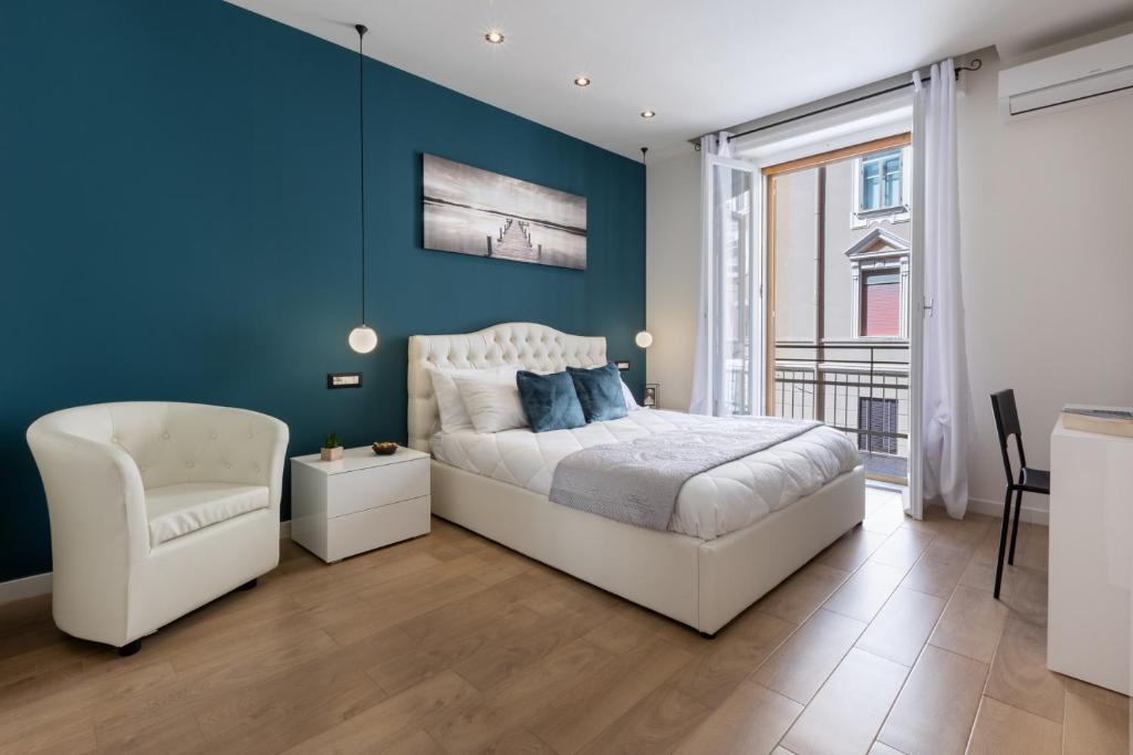 um quarto com uma cama branca e uma parede azul em Daddi rooms & apartment em Cagliari