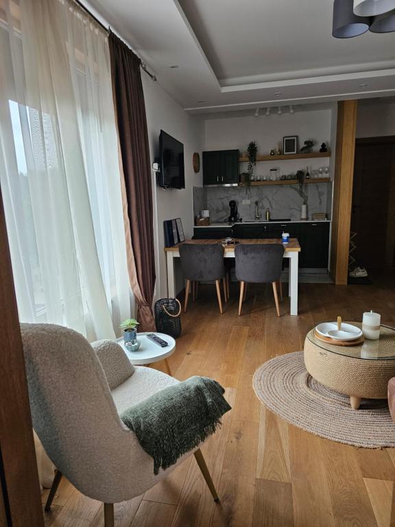 a living room with chairs and a table and a dining room at Avram in Zlatibor