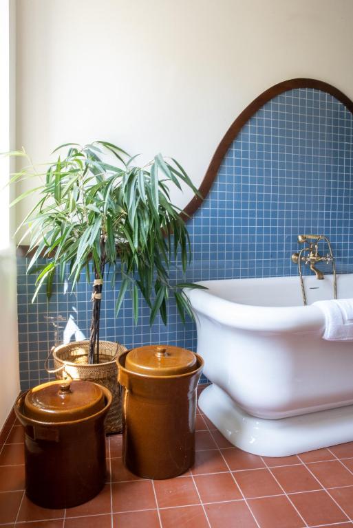 La salle de bains est pourvue de 2 plantes en pot et d'une baignoire. dans l'établissement Les Chambres de la Relève, à Marseille