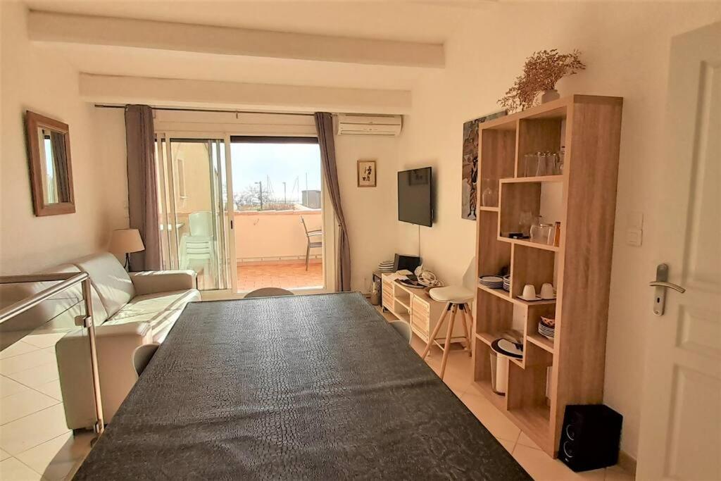 - un salon avec un canapé et une télévision dans l'établissement Appart 139, Le Neptuna, au Cap d'Agde