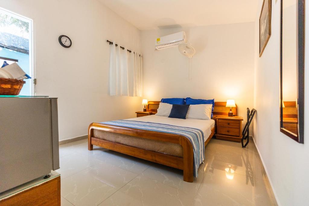 a bedroom with a bed with blue pillows and a tv at La casa azul in Cartagena de Indias