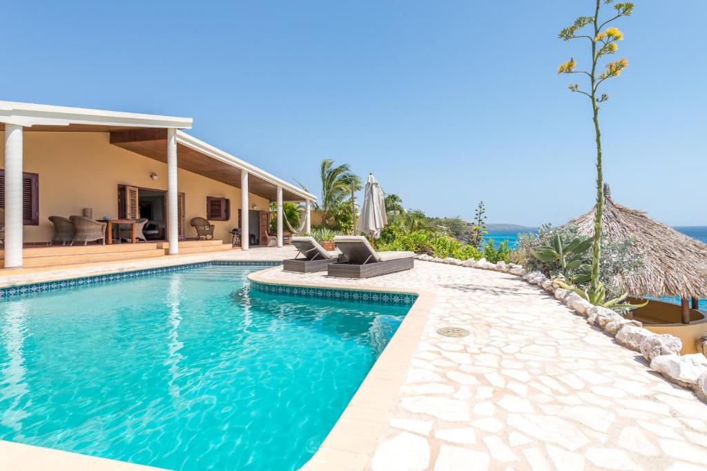 a villa with a swimming pool and a house at Pelican Villa in Lagun