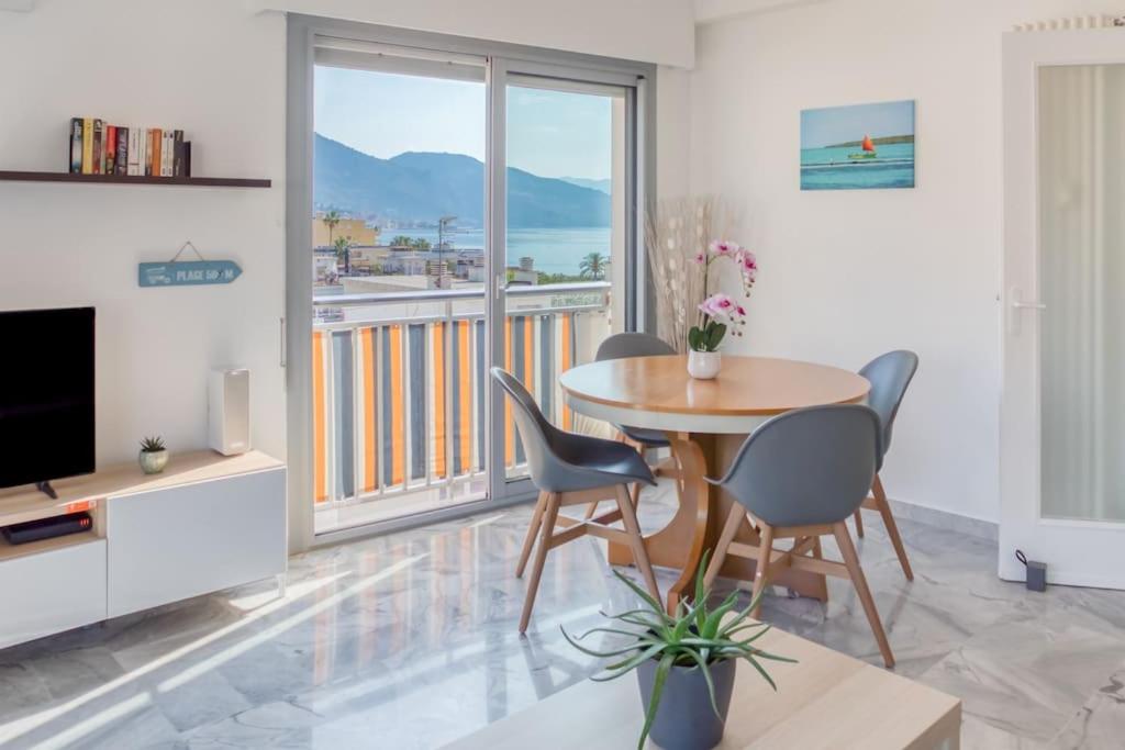 a living room with a table and chairs and a television at M6 1BDR Sea View balcony 2mins walk beach garage AC in Roquebrune-Cap-Martin