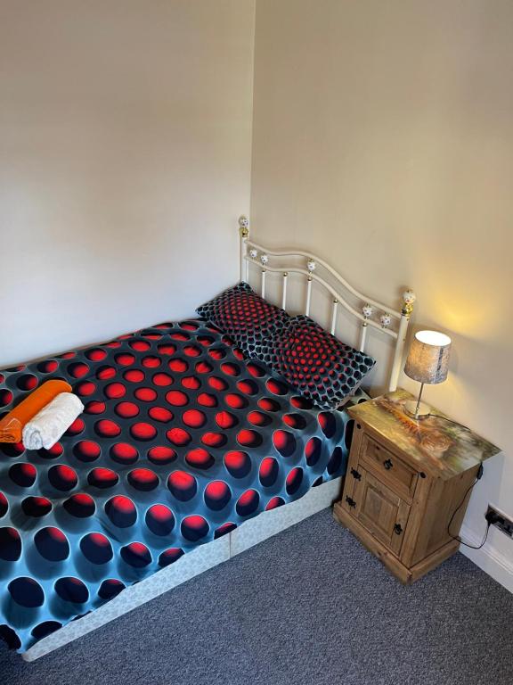 a bedroom with a bed with red and blue polka dots at Quite Broad Rest 5 in Longford