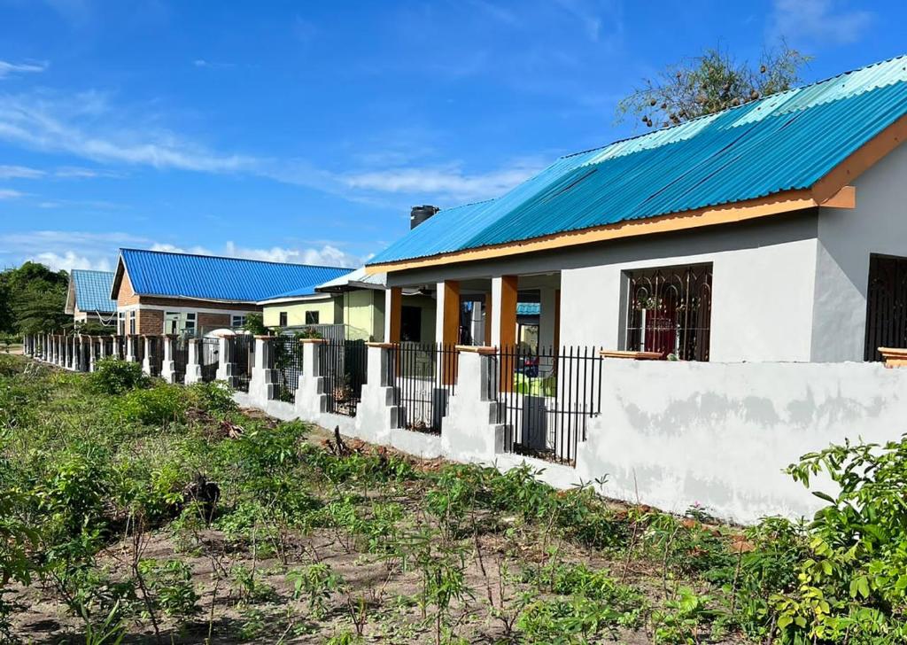 a row of houses with a blue roof at MHALO BEACH LODGE 