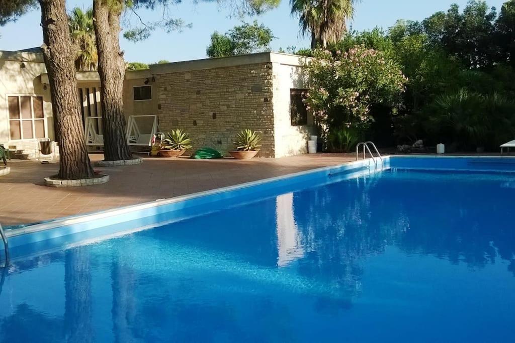 ein blauer Pool vor einem Haus in der Unterkunft Grande villa con piscina privata in Maruggio