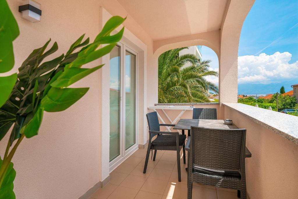 a balcony with a table and chairs and a window at Apartments Gerta with Terrace in Baška