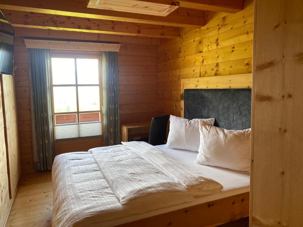 ein Schlafzimmer mit einem Bett in einem Holzzimmer in der Unterkunft Bio Bauernhof Perneißl Apartment in Bischofshofen