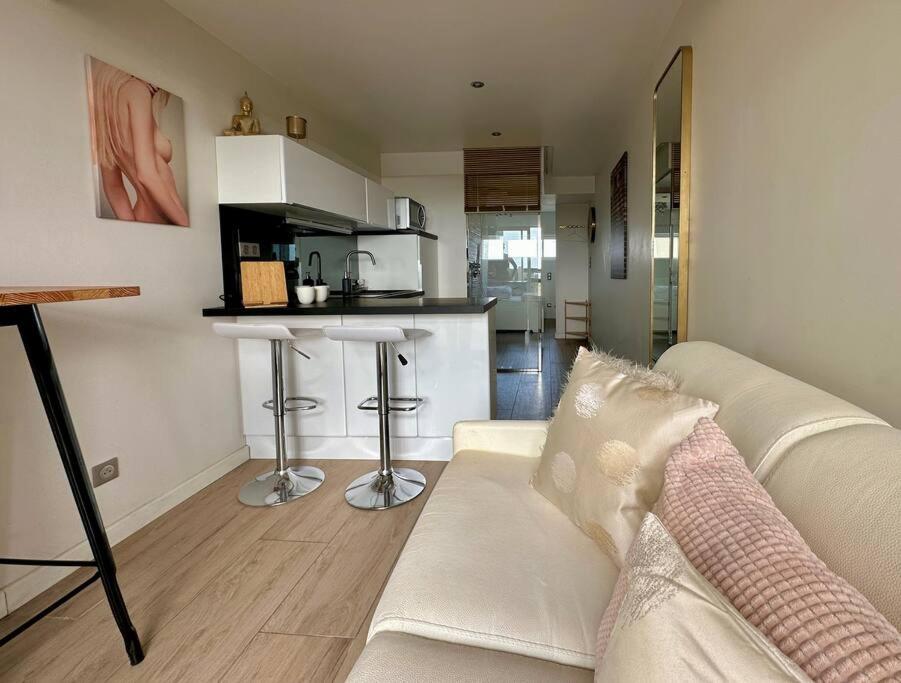 un salon avec un canapé blanc et une cuisine dans l'établissement Appart 373, Port Nature 3 au village naturiste, au Cap d'Agde