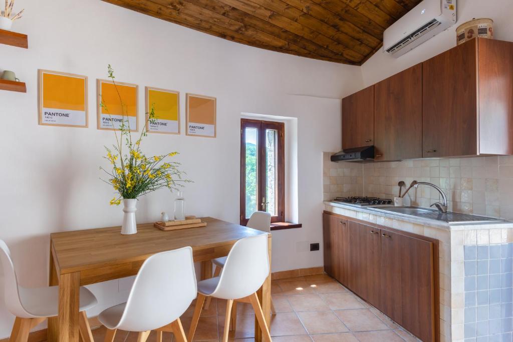 - une cuisine avec une table en bois et des chaises blanches dans l'établissement La terrazza sul Lete, à Prata Sannita