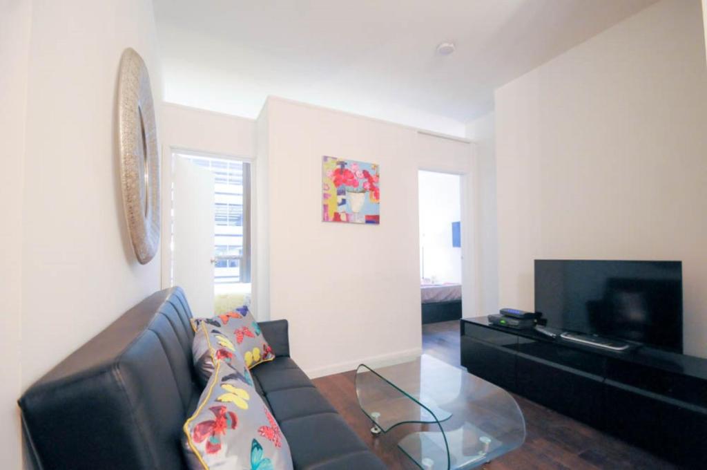 uma sala de estar com um sofá e uma televisão em 2 BR in Wall Street em Nova York