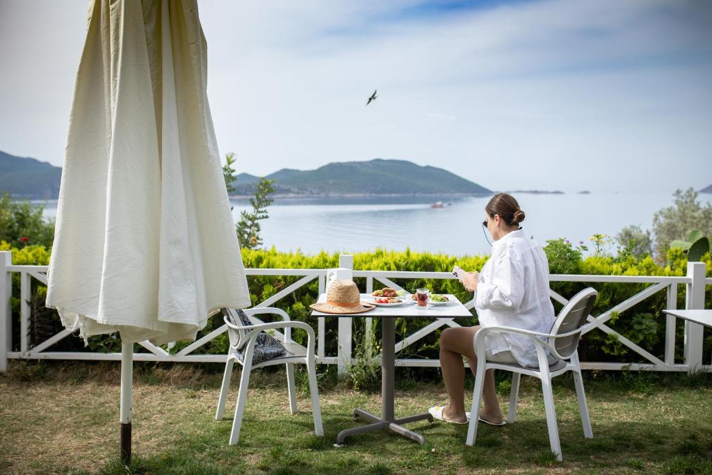 uma mulher sentada numa mesa com um prato de comida em Payam Hotel em Kas