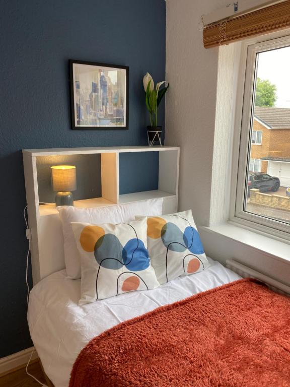 a bedroom with a white bed with a window at Birch Avenue House, entire house with 4 bedrooms, free parking, free WI-FI, Smart TV, washing machine, easy access to M1 in Ilkeston