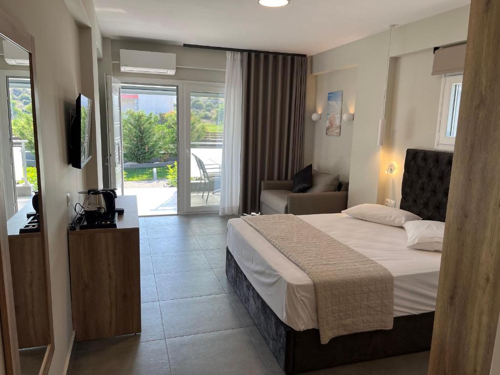 um quarto de hotel com uma cama e uma televisão em Astra Sarti Luxury Suites em Sarti
