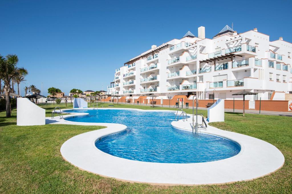 une piscine en face d'un grand immeuble dans l'établissement Pierre & Vacances Almeria Roquetas de Mar, à Roquetas de Mar