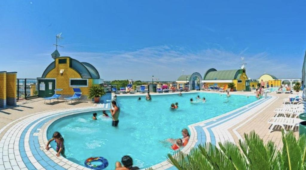 een groep mensen in een zwembad in een resort bij Residence Cristoforo Colombo - Carraro Immobiliare - Family Apartments in Caorle