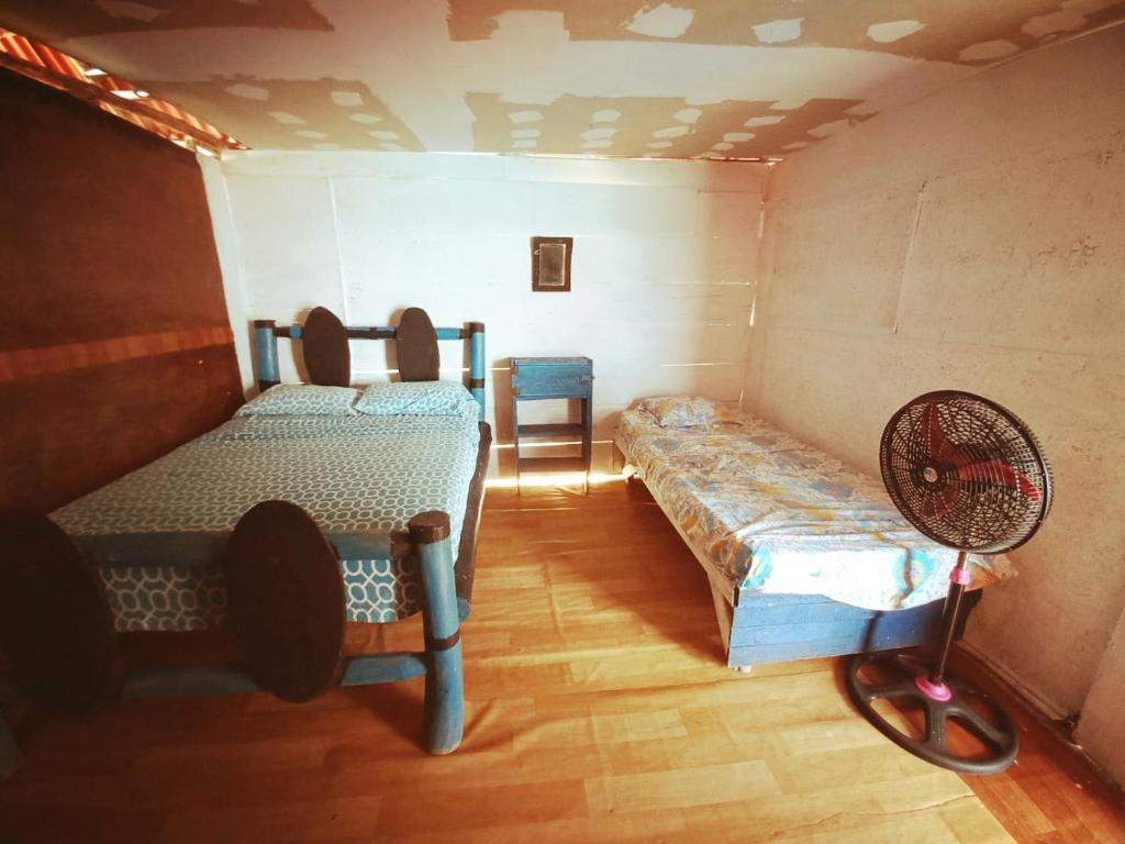 um pequeno quarto com 2 camas e uma ventoinha em Playa Tortuga Cabaña em Playa Blanca
