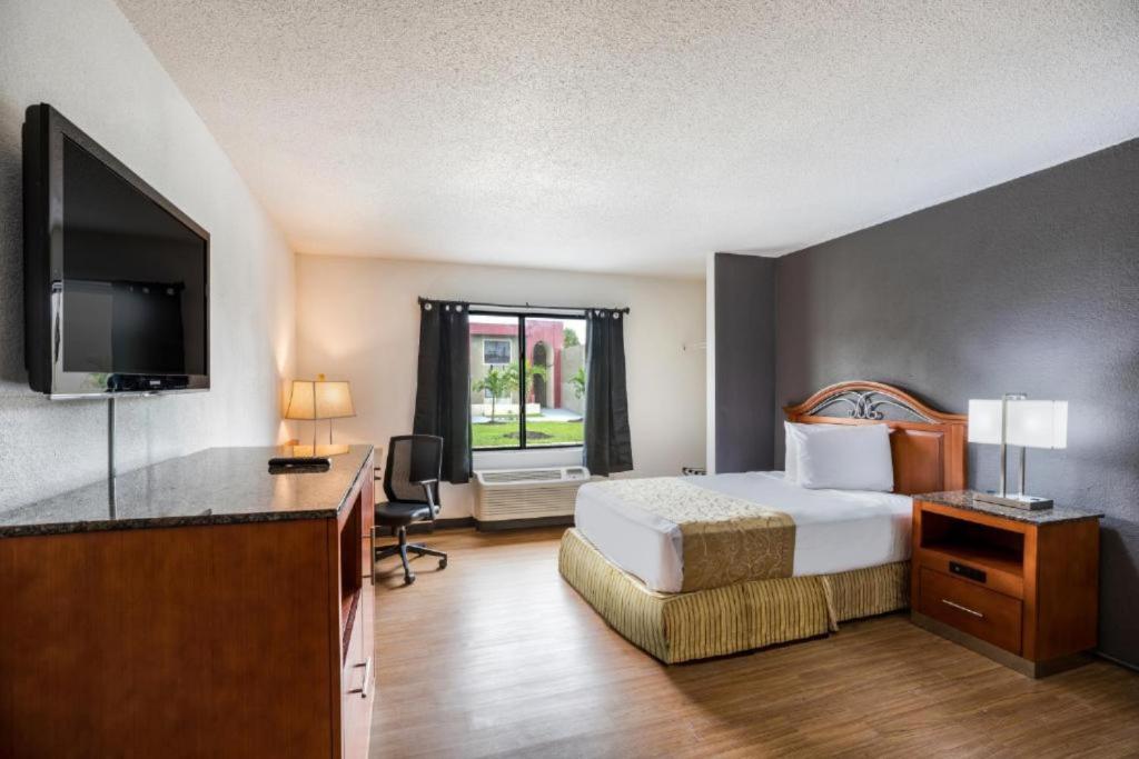 Habitación de hotel con cama y TV de pantalla plana. en OYO Hotel Orlando Airport, en Orlando