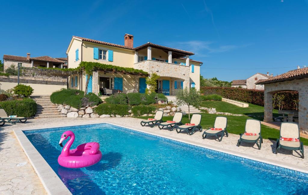 uma piscina com um flamingo rosa em frente a uma casa em Azzurra em Jakići