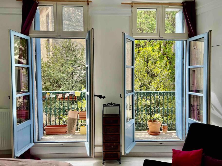 une pièce avec des portes ouvertes sur un patio dans l'établissement La charmante maison aux volets bleu - Montpellier, à Montpellier