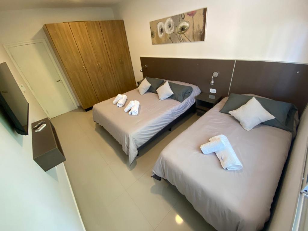 Dos camas en una habitación de hotel con toallas. en Cálido y Amplio Dpto Céntrico 1D en Formosa