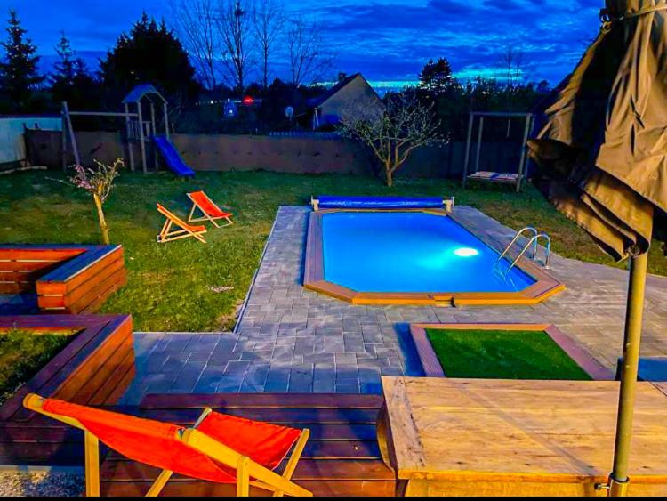 una piscina in un cortile con sedie e tavolo di Loft Paradise a Győr