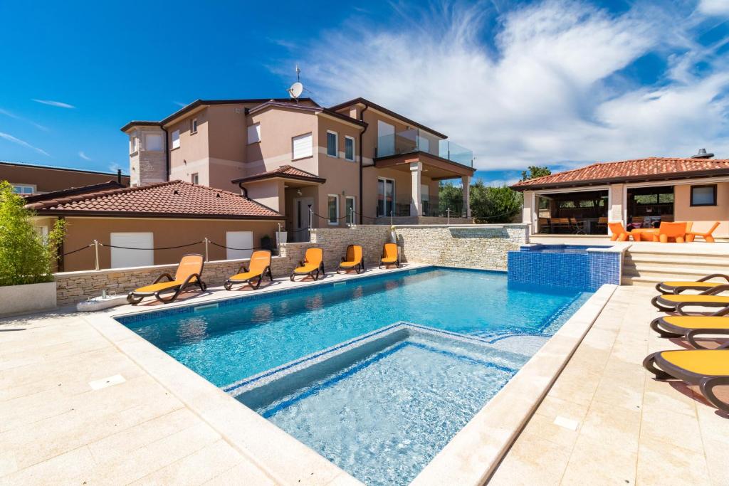 a villa with a swimming pool and a house at Istrakamen in Ližnjan