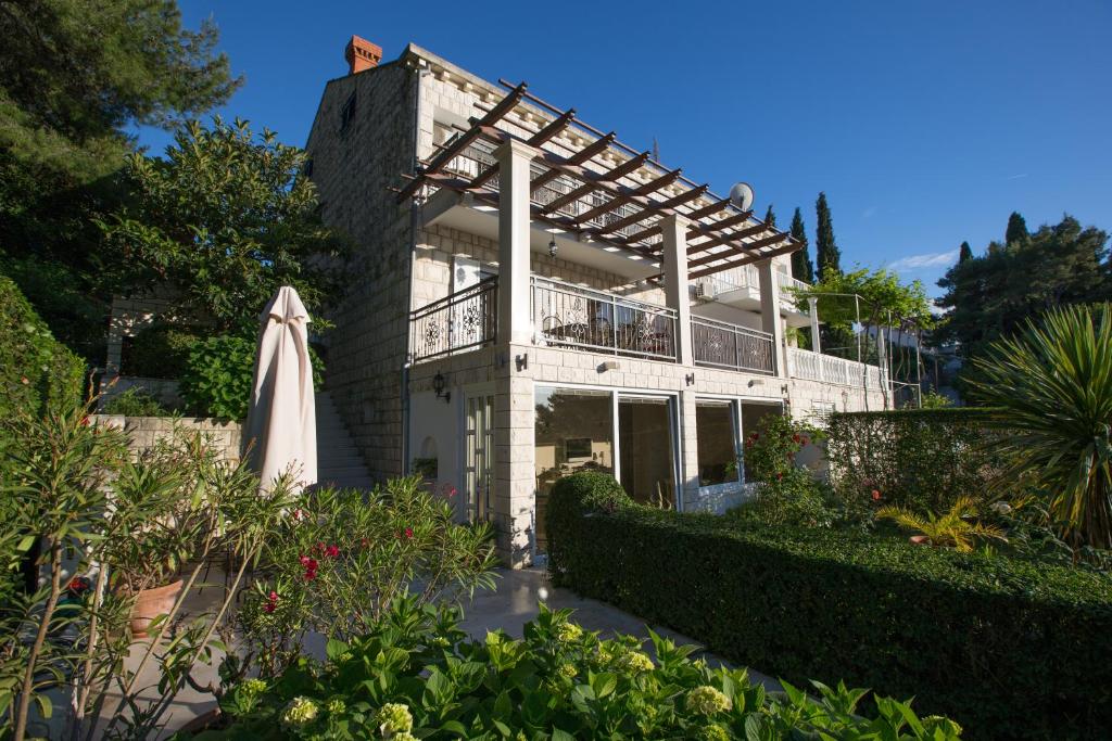 a building with an umbrella and a garden at La Perla in Cavtat